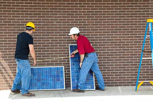 Two workmen measuring solar panels to illustrate the size options of solar panels in Australia